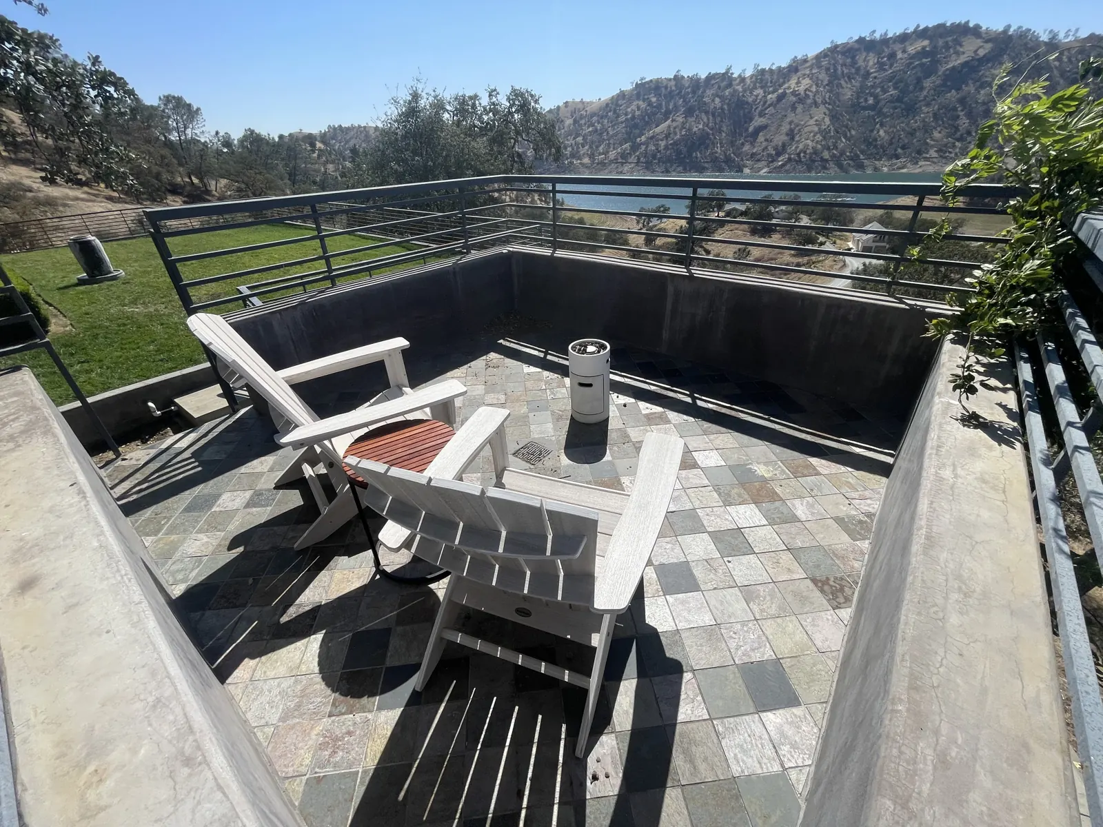 Balcony with white Adirondack chairs and a view of the lake