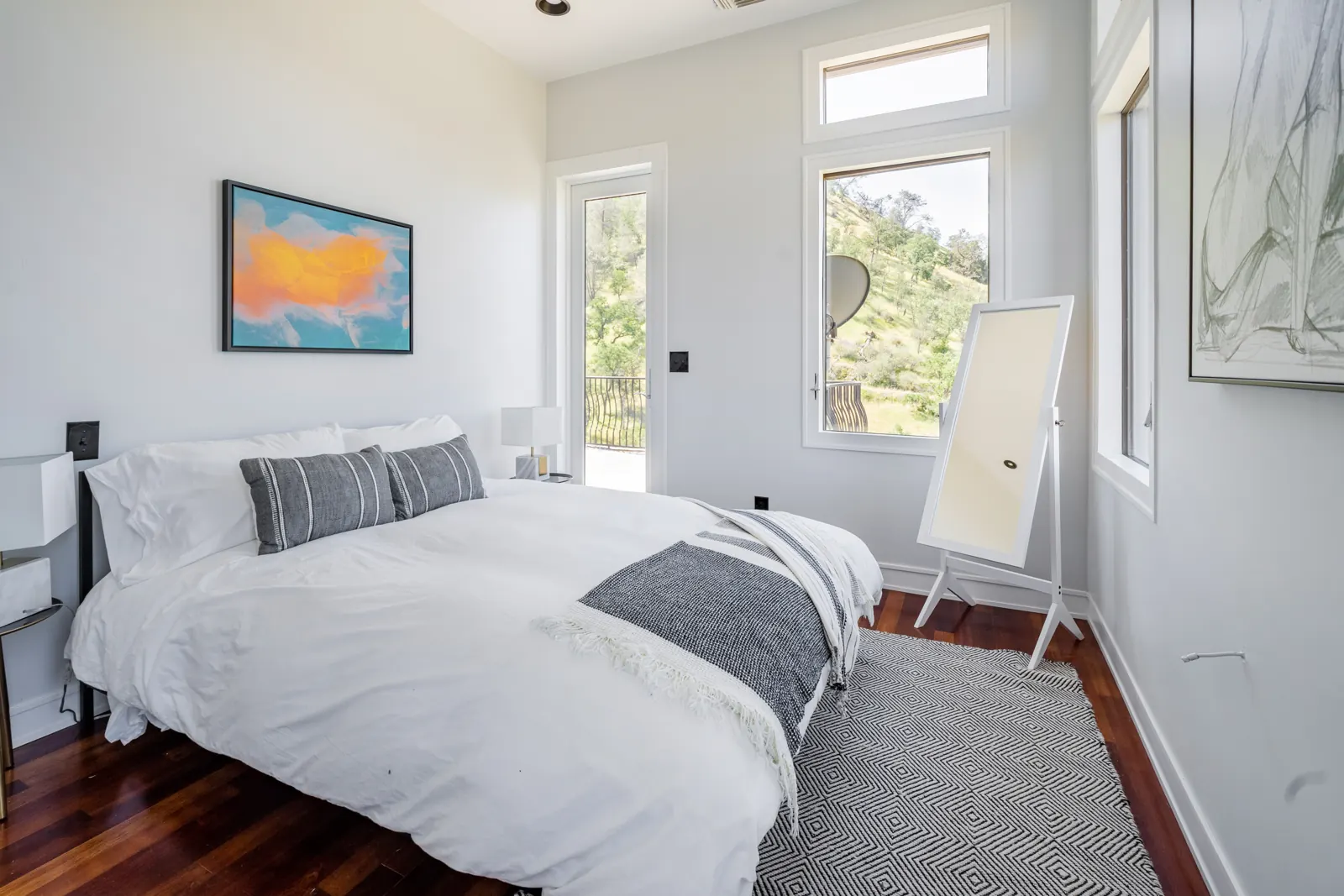 Bedroom with a queen bed, artwork and hill views