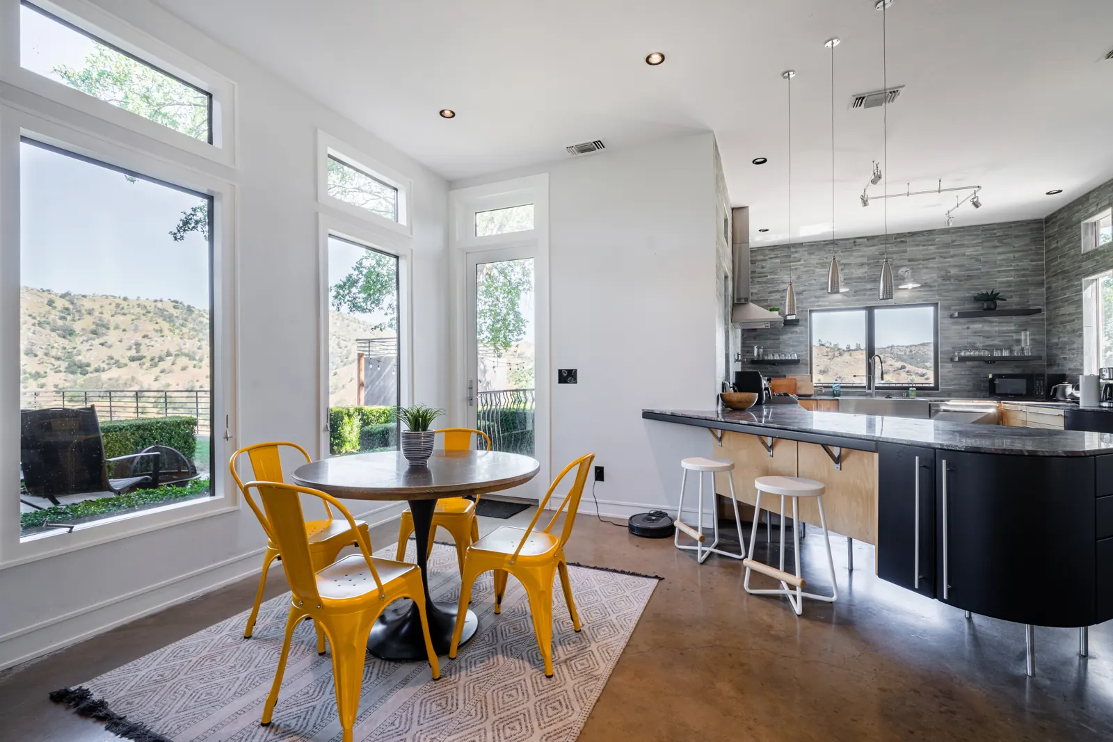 Breakfast nook with yellow chairs beside the kitchen island