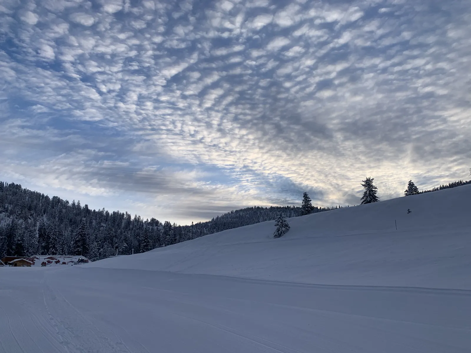 Wide groomed slope under a dappled winter sky at China Peak