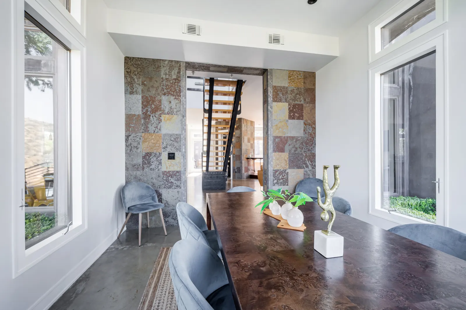 Dining table in front of the slate wall and staircase