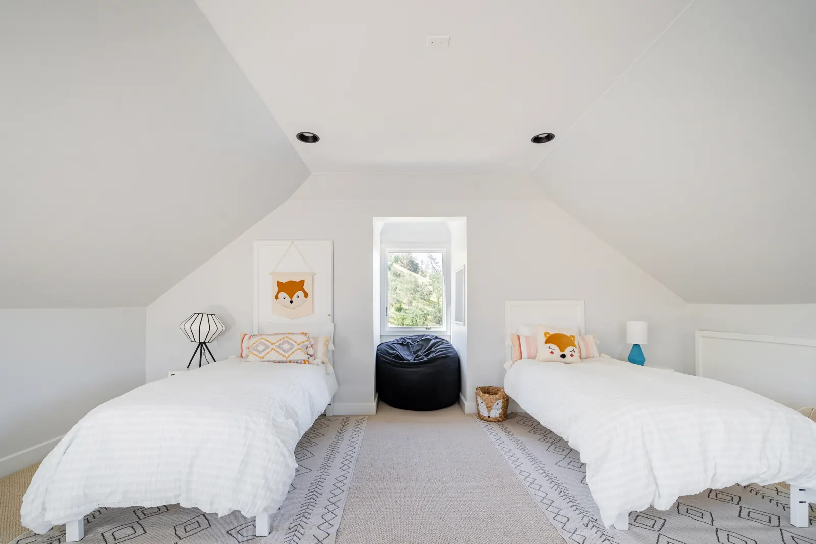 Children's loft under the eaves with twin beds and a beanbag