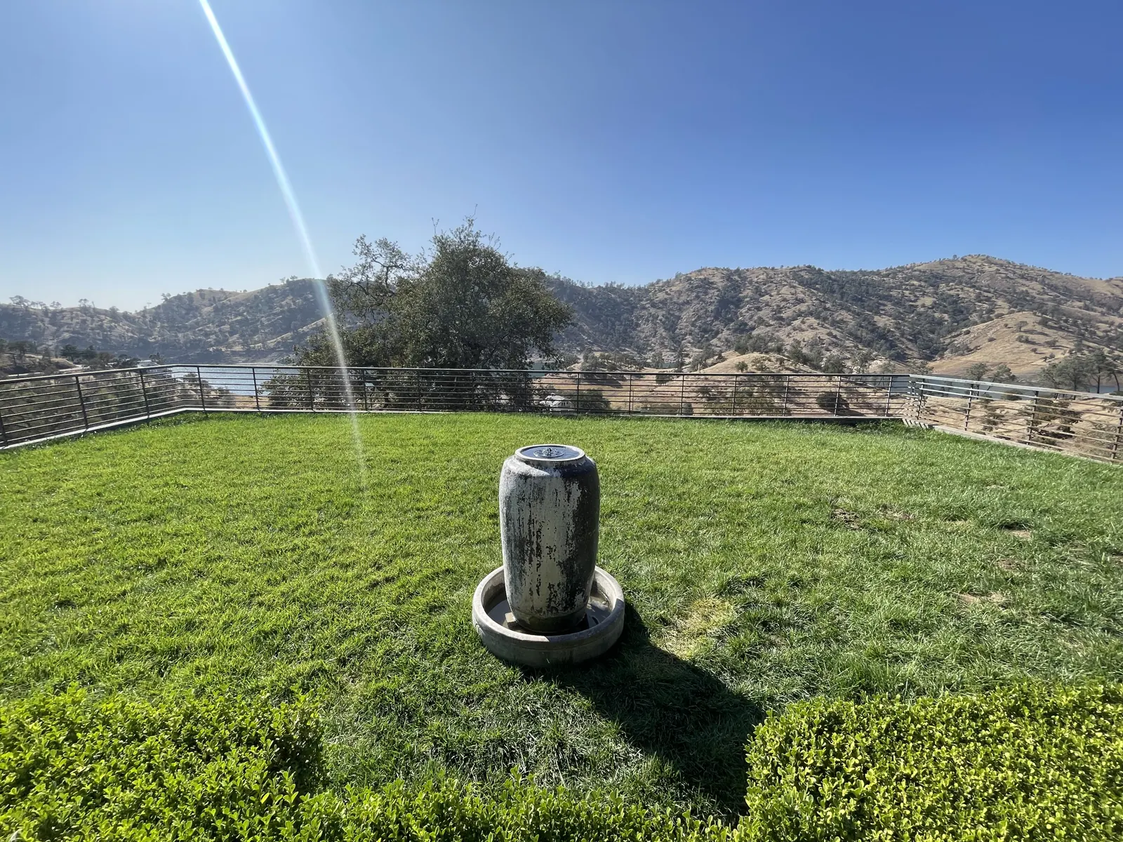 Lawn with a stone fountain and the lake and hills beyond