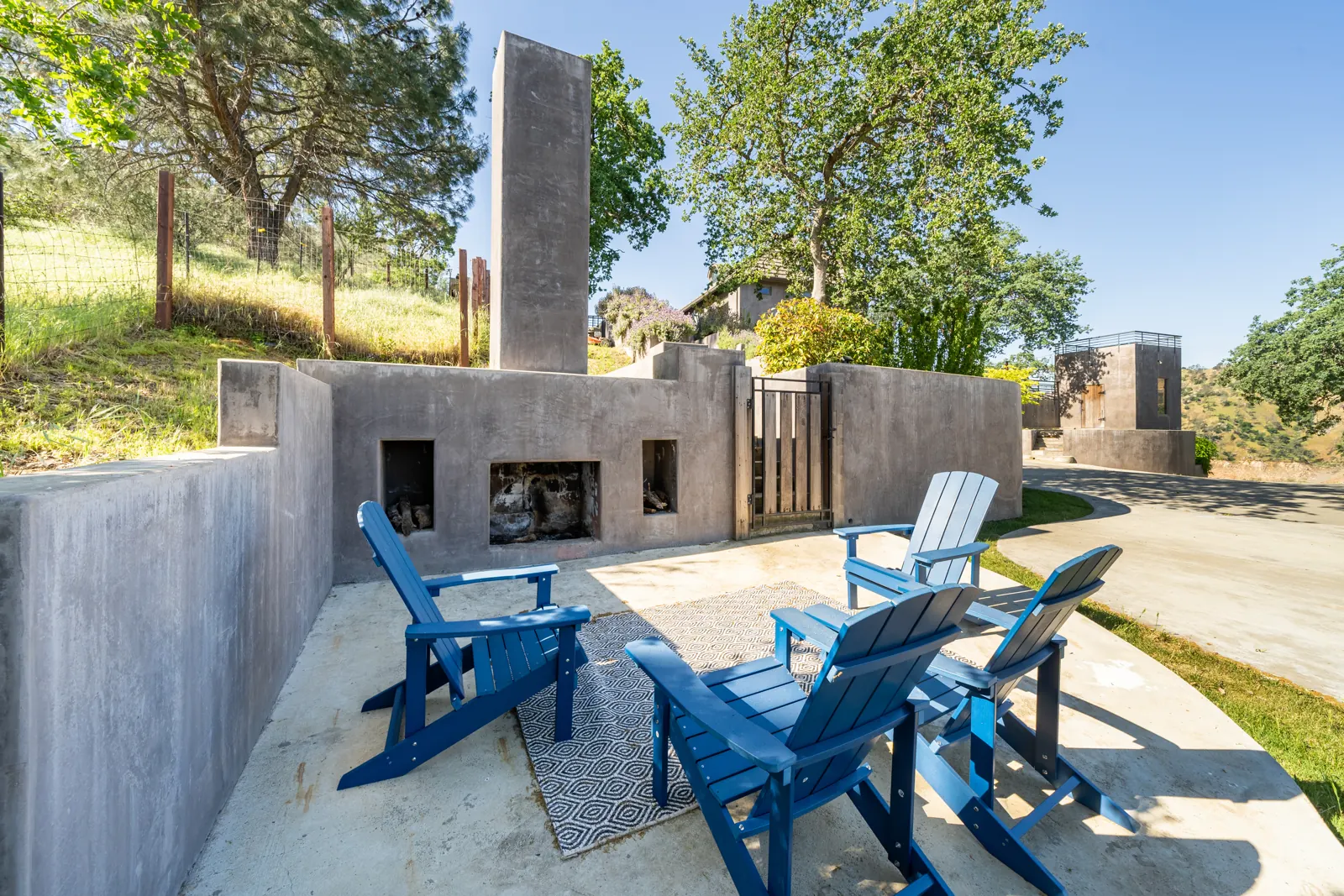Blue Adirondack chairs around the outdoor fireplace