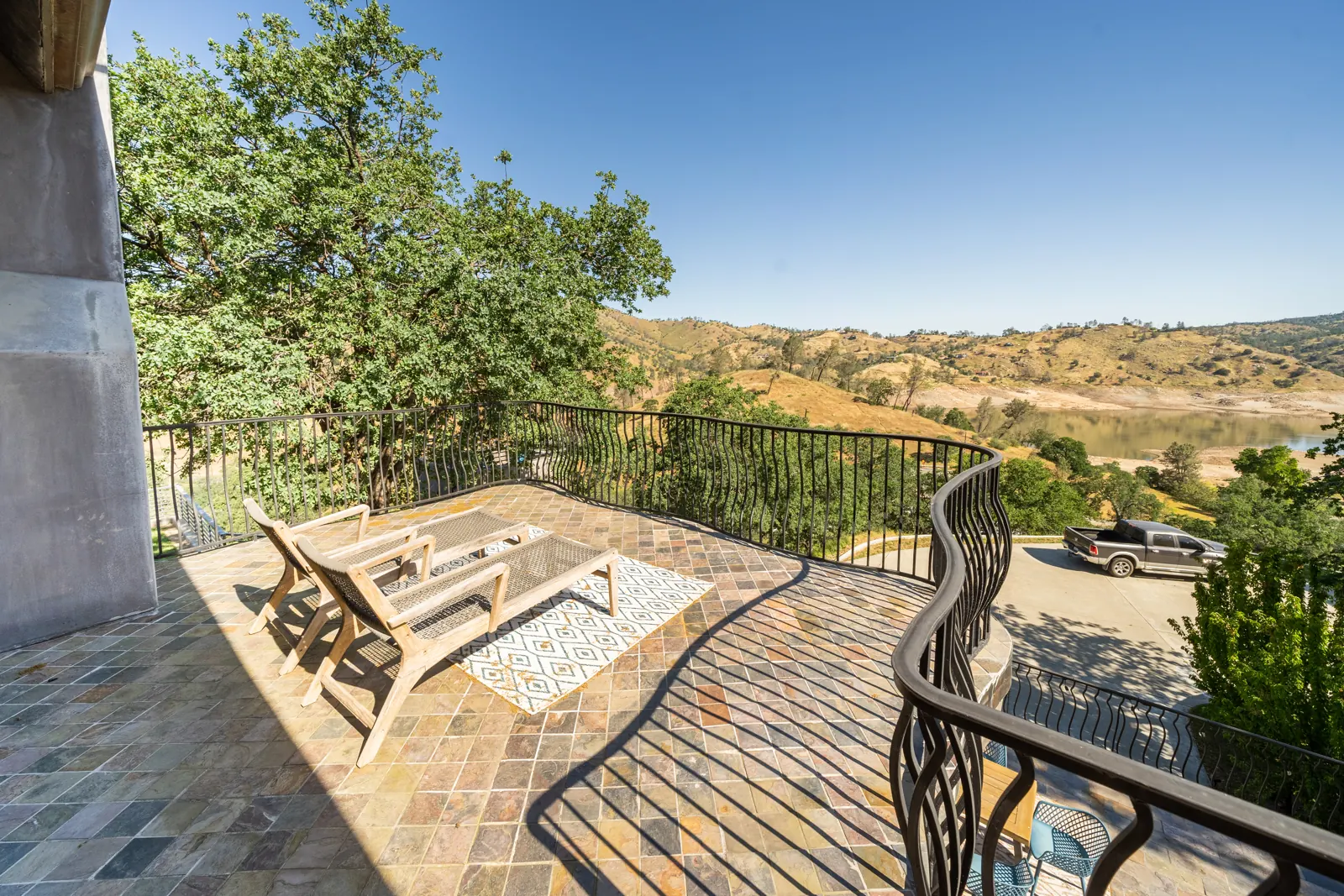 Stone balcony with lounge chairs looking out over the hills and Millerton Lake