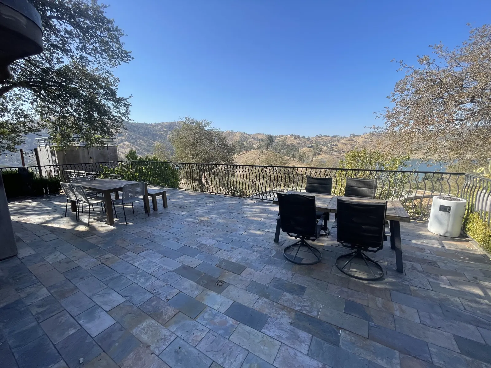 Paved terrace with lounge chairs and dining sets above the lake