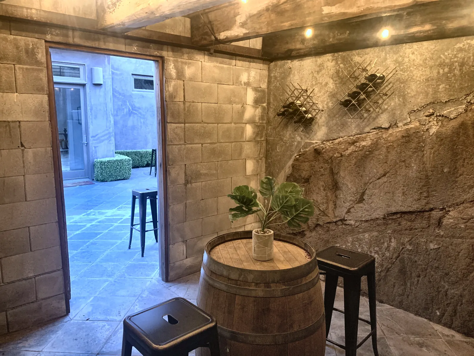 The wine cellar carved into the hillside rock, with a barrel table and stools